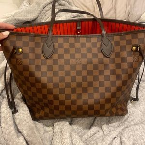 Louis Vuitton Neverfull bag in brown with red inside.